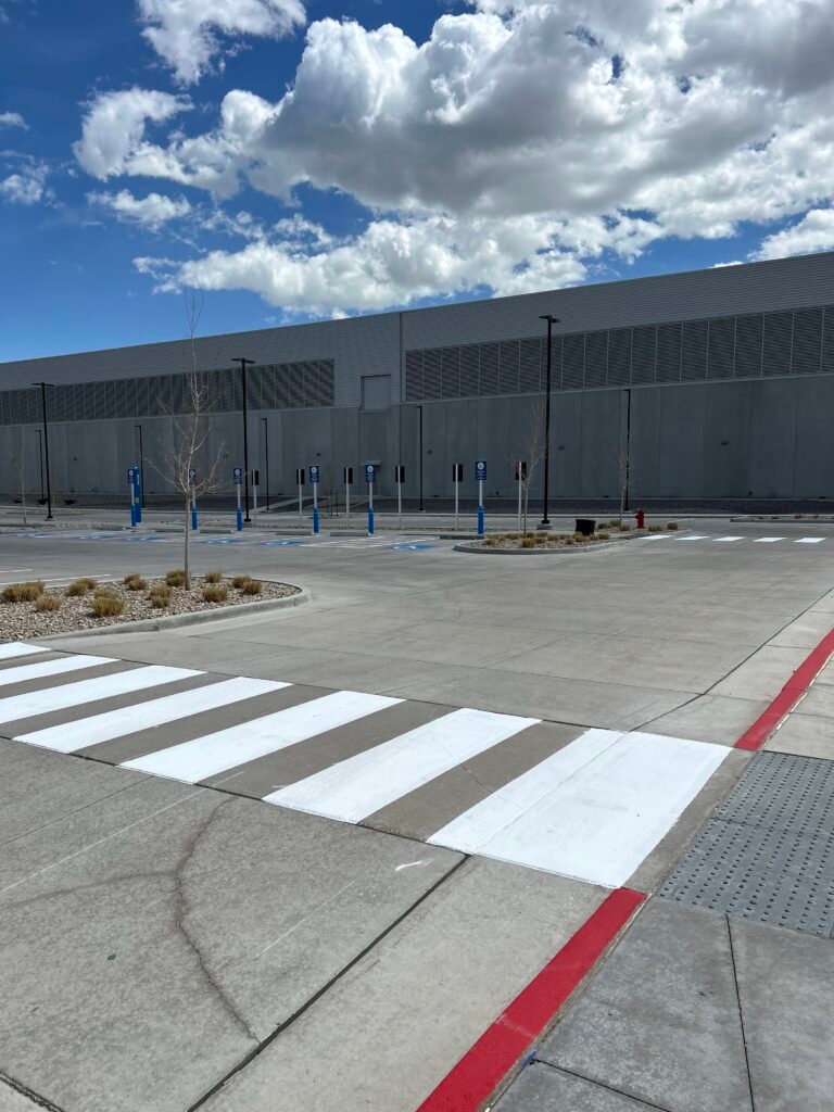 Freshly painted crosswalk and parking lot striping with wheel stops