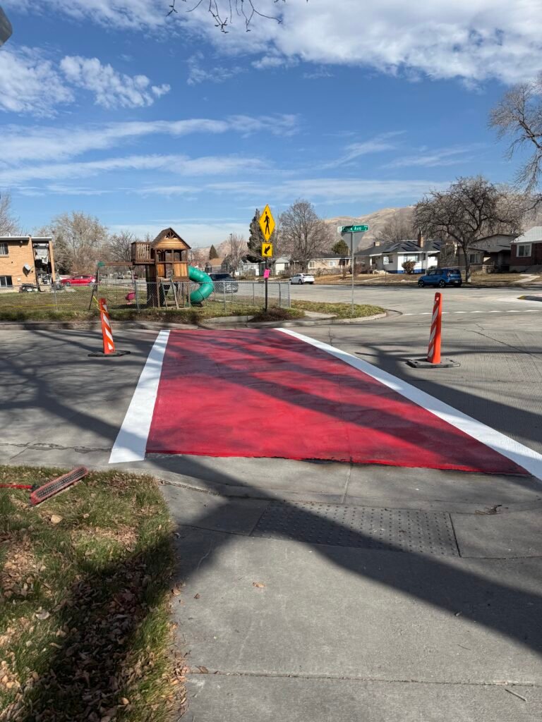 High-visibility red crosswalk pavement marking with clean border lines